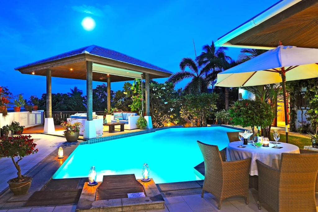 uma piscina com cadeiras, uma mesa e um guarda-sol em Samui Blu, villa with private pool em Praia de Choeng Mon