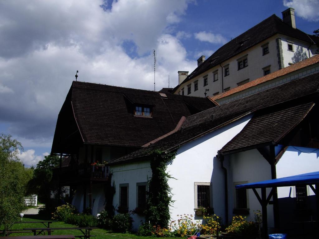 a white building with a brown roof at Penzion U Tkadlen in Jindřichŭv Hradec