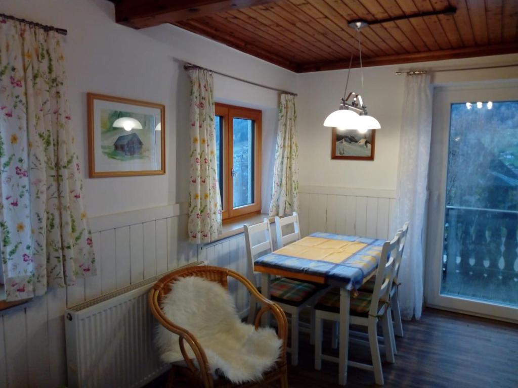 comedor con mesa, sillas y ventana en Haus Höber, en Archkogel