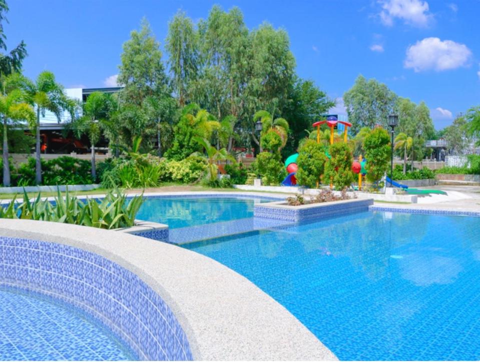 a large swimming pool with a playground in the background at Segara Residencias in Olongapo