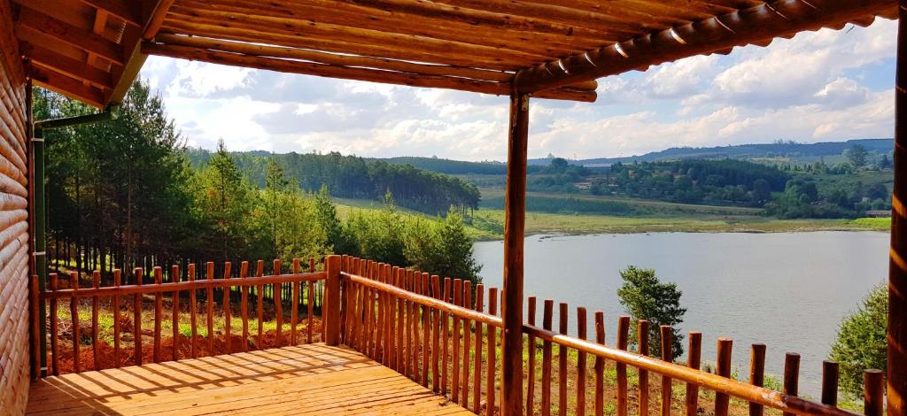 a wooden deck with a view of a lake at Stanford Lake lodge in Haenertsburg