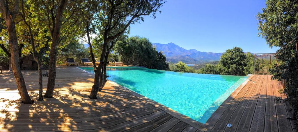 a swimming pool with trees and mountains in the background at Hotel A Piattatella in Monticello