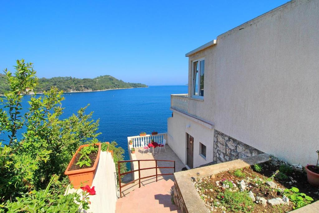 une maison avec vue sur l'eau dans l'établissement Apartments Filipović, à Sobra