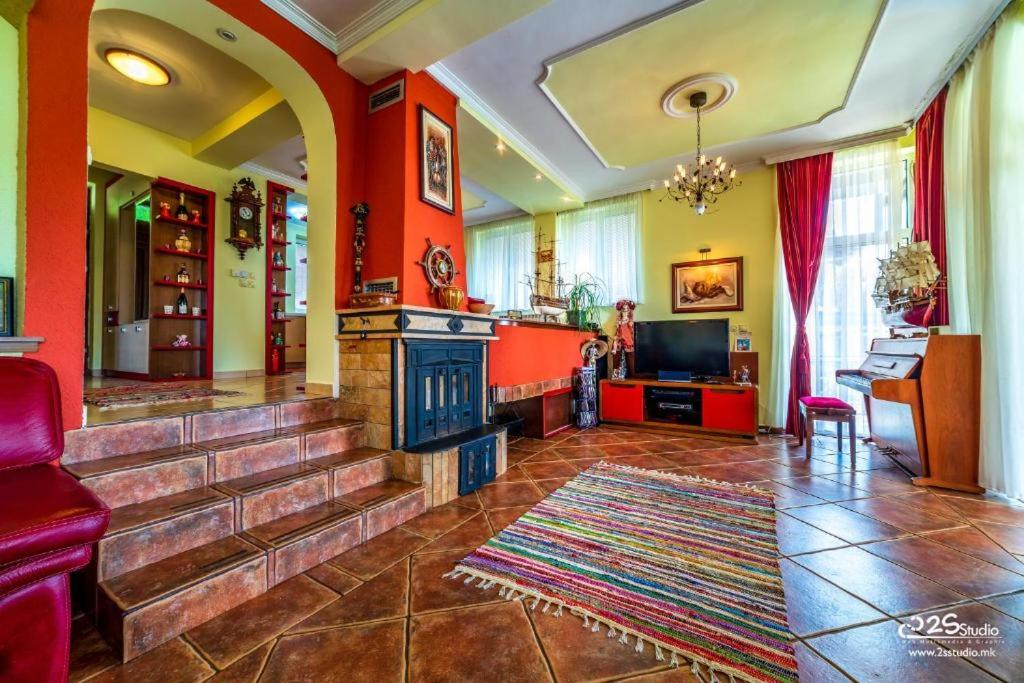 sala de estar con chimenea y paredes rojas en Villa Lake View, en Ohrid