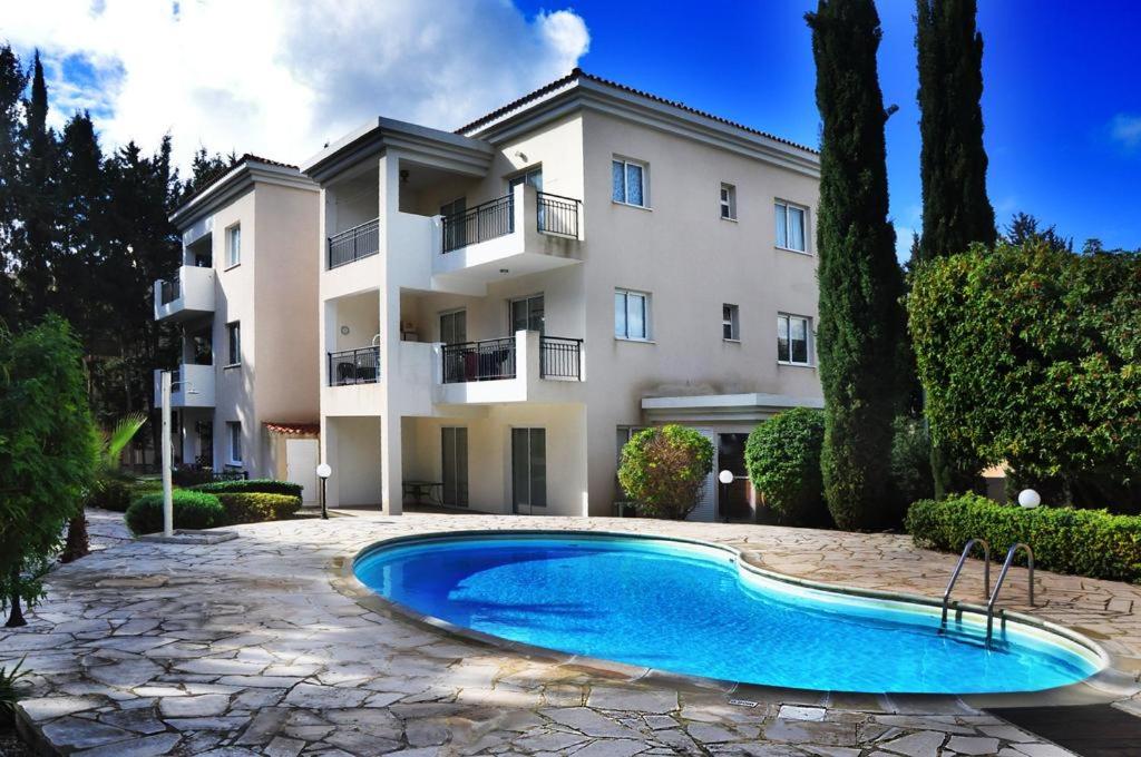 une villa avec une piscine en face d'un bâtiment dans l'établissement D3 - Paphos Riviera - Kato Paphos, à Paphos