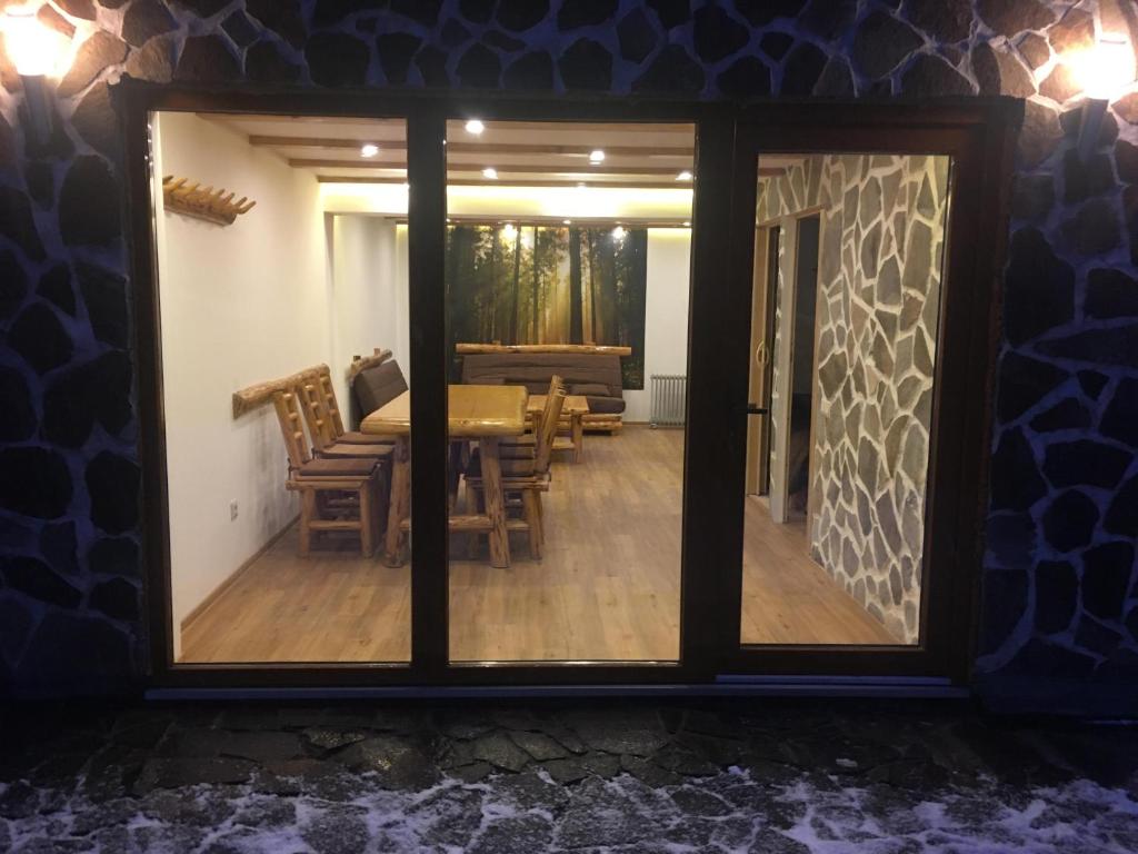 a view of a dining room through a window at László apartman in Harghita-Băi