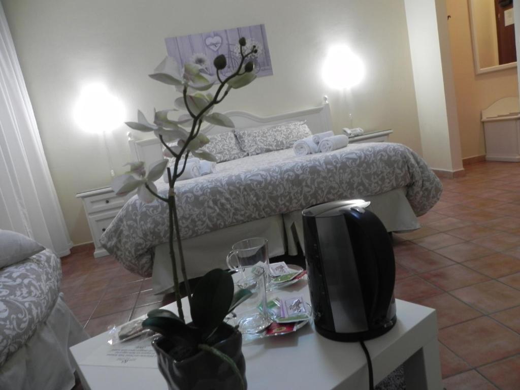 a room with a bed and a table with a tv at Hotel Villa Romana in Piazza Armerina