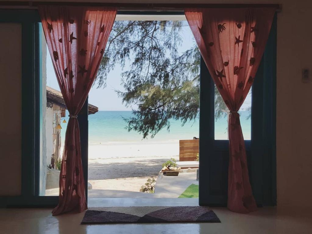 une porte ouverte avec vue sur la plage dans l'établissement Maliblues Bed & Art Gallery, à Chumpon