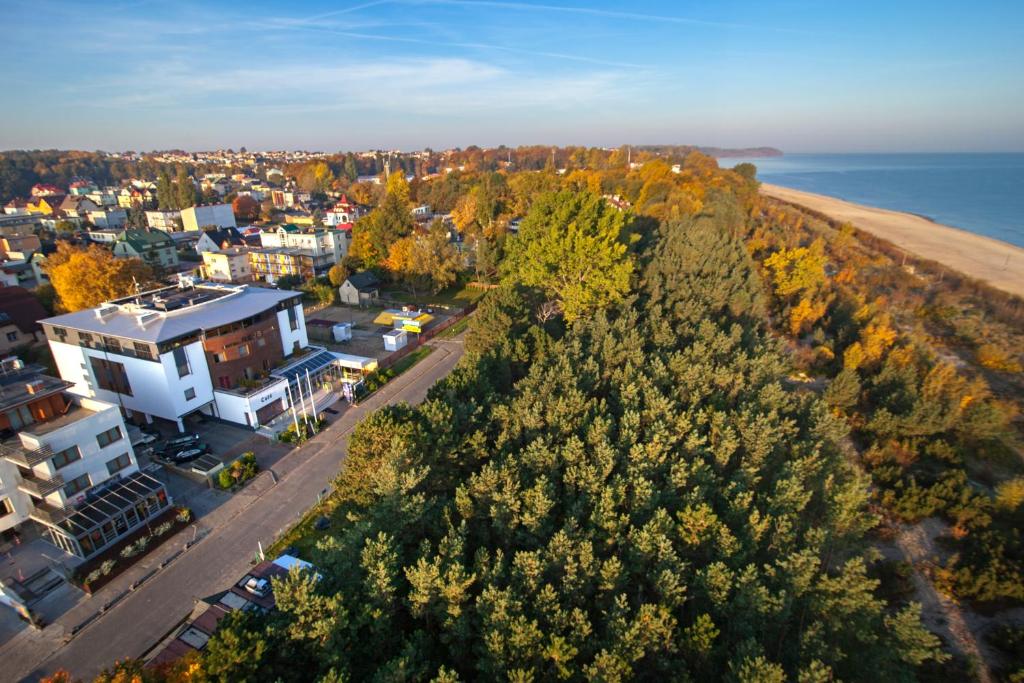 an aerial view of a city with trees and the ocean at Hotel Rejs in Władysławowo