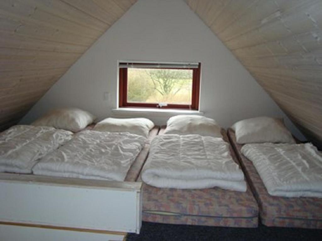 2 camas individuales en una habitación con ventana en Grindsted Aktiv Camping & Cottages en Grindsted