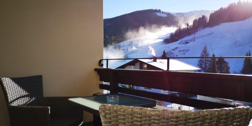 un balcón con mesa y sillas y una foto de una montaña en Appartement Bella Vista en Bad Kleinkirchheim