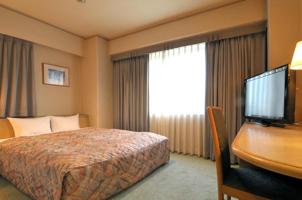 Postel nebo postele na pokoji v ubytování Takarazuka Washington Hotel