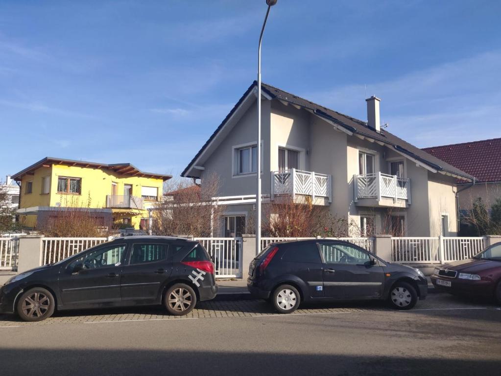 dos autos estacionados en un estacionamiento frente a una casa en Relax - Ferienhaus in Wien en Viena