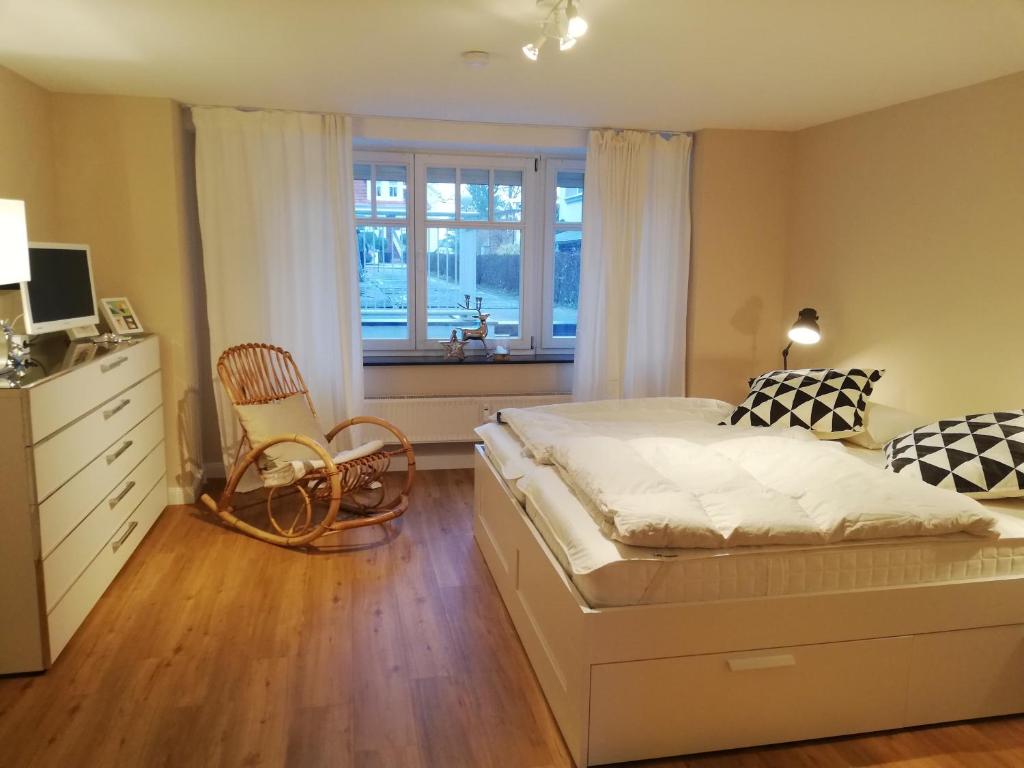 sypialnia z łóżkiem, komodą i oknem w obiekcie Seepferdchen w mieście Timmendorfer Strand