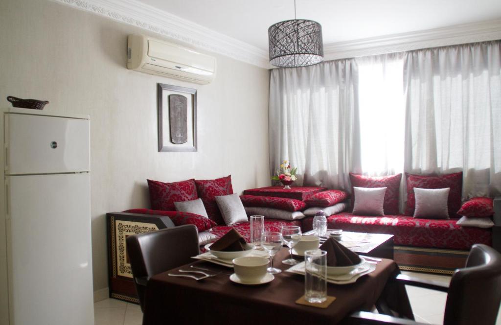 a living room with a table and a couch at Apparts-hôtel ISNI in Agadir