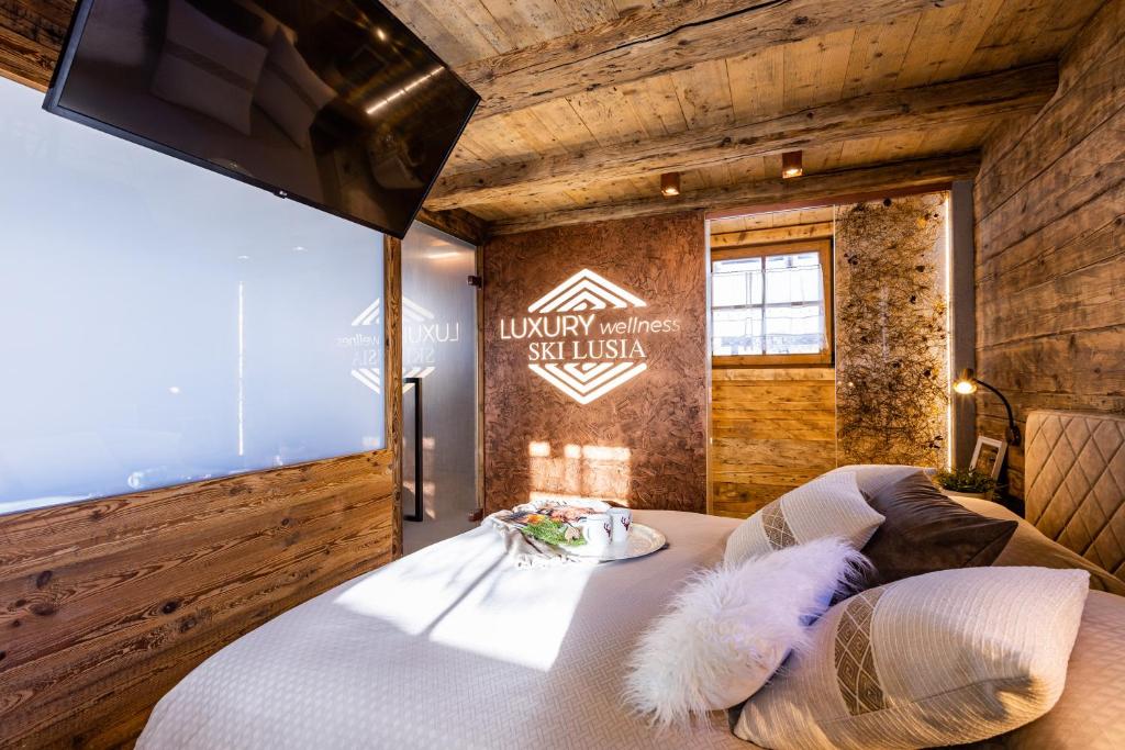 a bedroom with a bed with a large window at Luxury Wellness Lusiaski in Bellamonte
