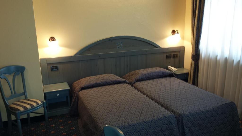 Pokój hotelowy z łóżkiem i krzesłem w obiekcie Hotel Pesek w mieście San Dorligo della Valle