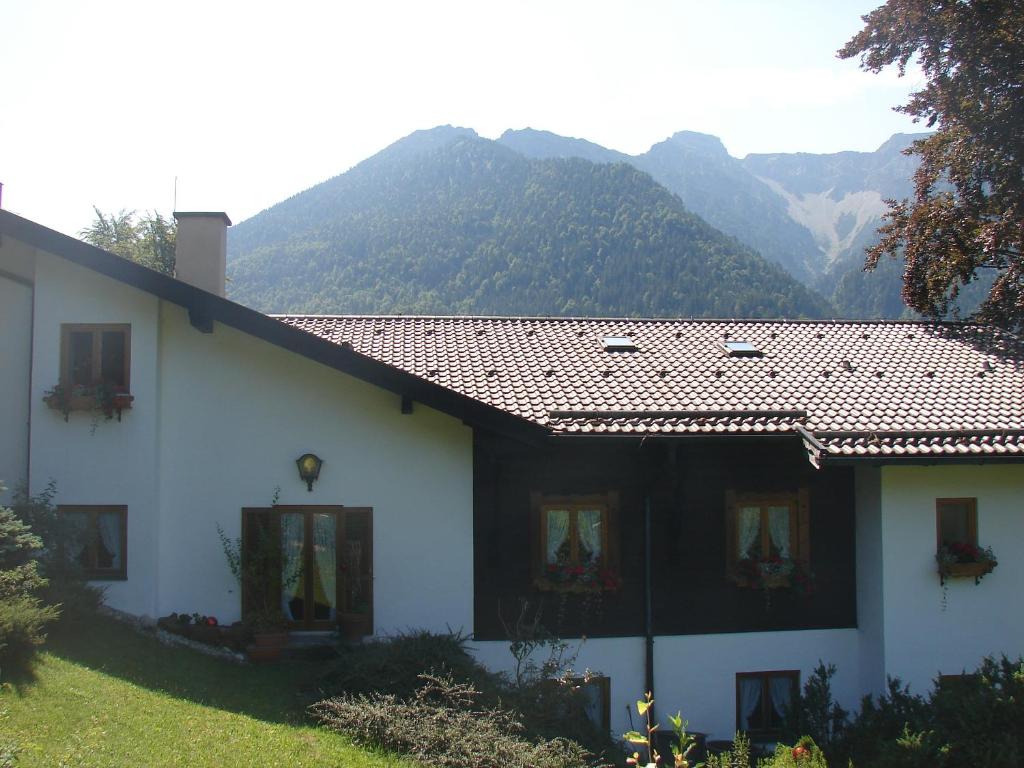 a white house with mountains in the background at Tonihof Eschenlohe in Eschenlohe
