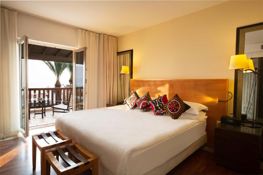 a bedroom with a large bed and a balcony at The Marmara Bodrum - Adult Only in Bodrum City