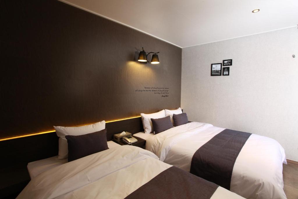 S& Hotel في دايجون: سريرين في غرفة فندق بسريرين