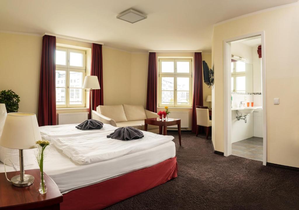 une chambre d'hôtel avec un lit et un canapé dans l'établissement SchlafGut AppartementHotel, à Leipzig