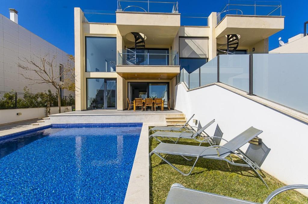 a villa with a swimming pool and a house at Villa Aqua in Alcudia