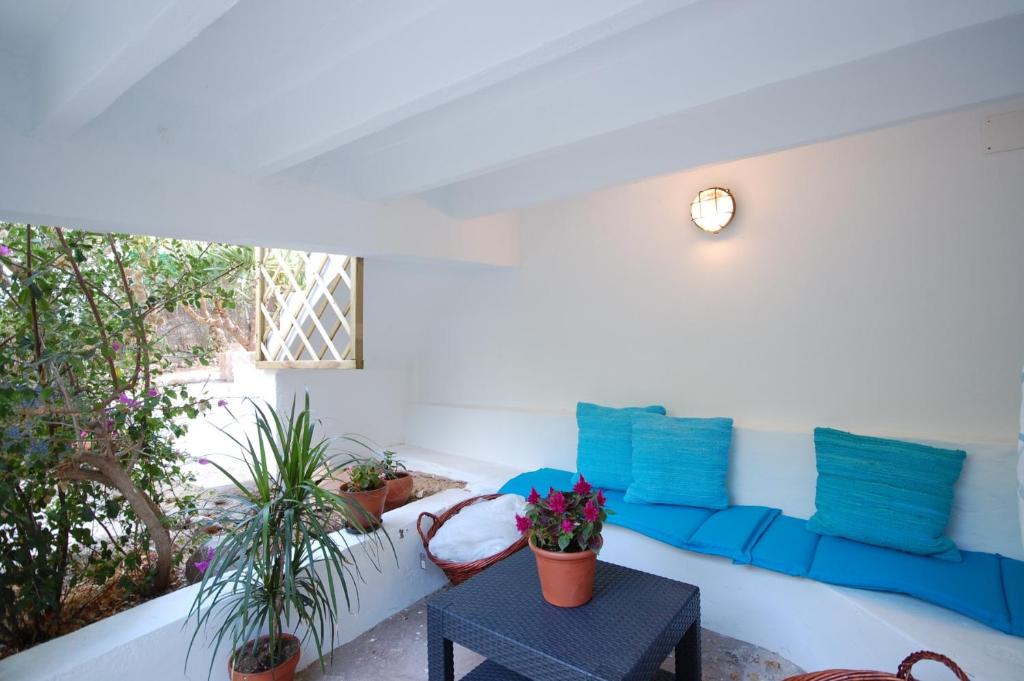 a living room with a white couch and blue pillows at YupiHome Holiday Home Kety in Portals Nous