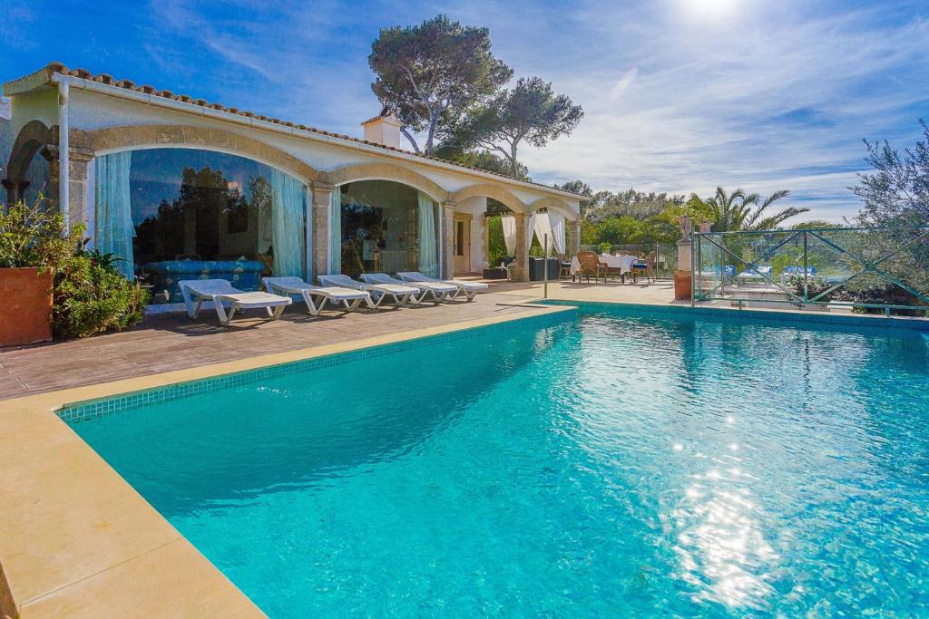a swimming pool in front of a house at YupiHome Villa Romana Bonaire in Alcudia