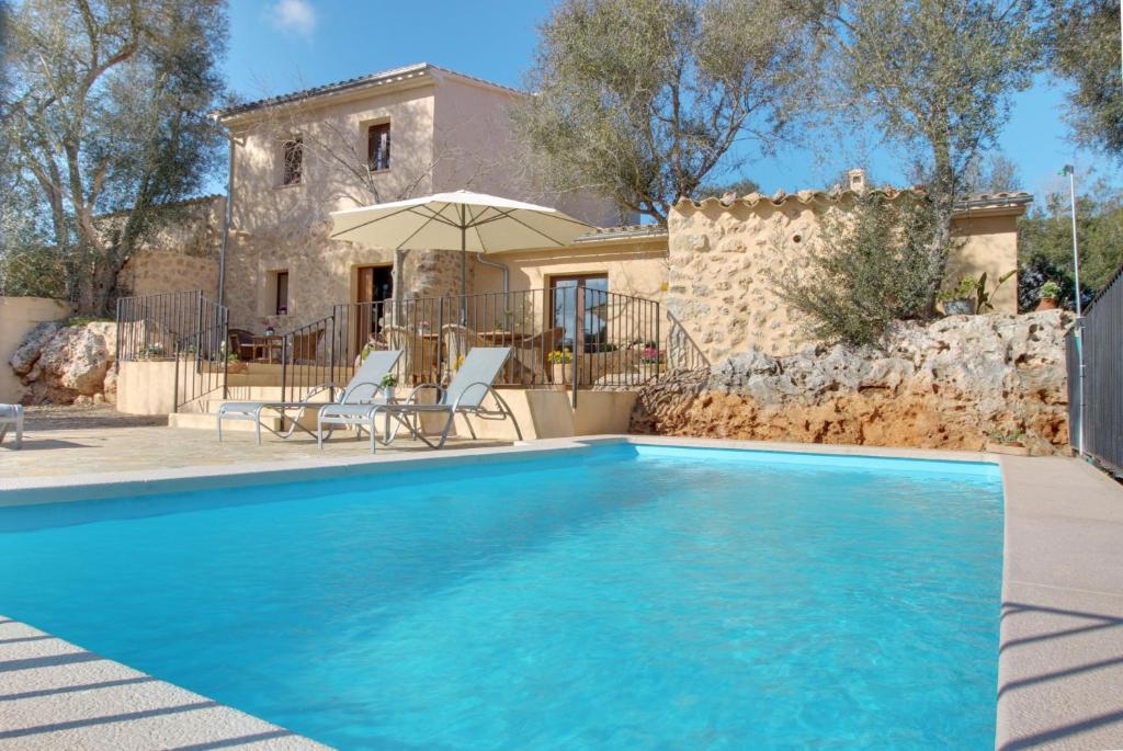 a swimming pool in front of a house at YupiHome Finca S'Erissal de Costitx in Costitx