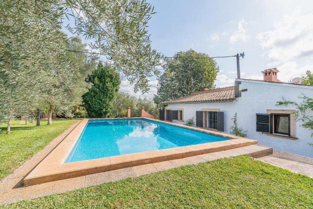 a swimming pool in a yard next to a house at YupiHome Finca Can Lluc in Alaró