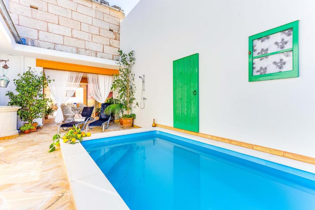 - une piscine dans une maison dotée d'un mur en briques dans l'établissement YupiHome Cantino House, à Santa Margalida