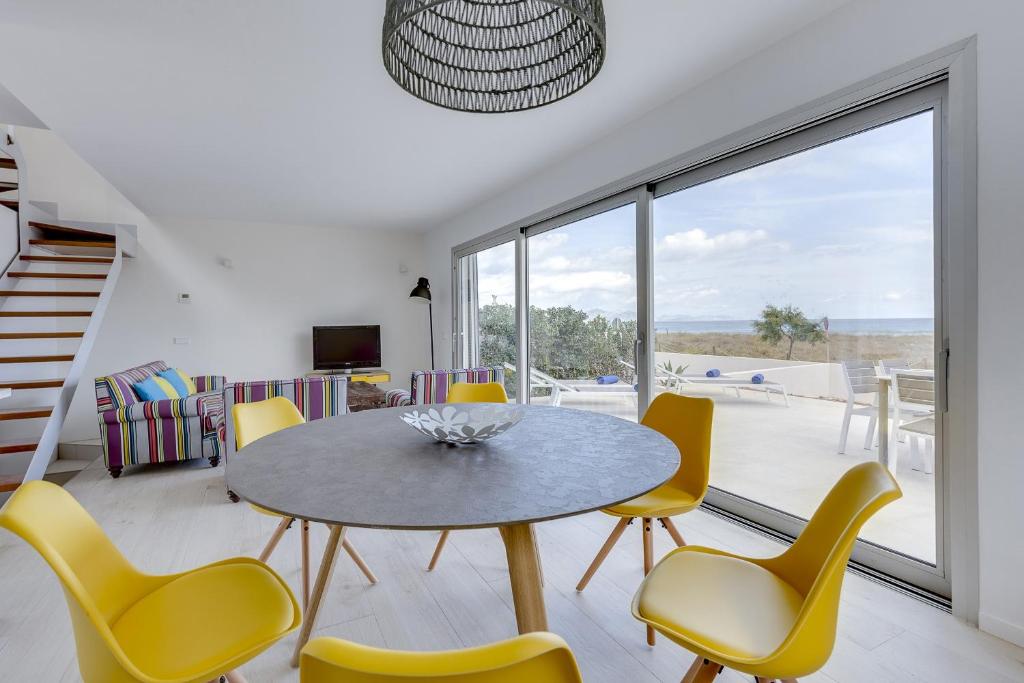 ソン・セッラ・デ・マリーナにあるYupiHome Son Serra First Line Villaのダイニングルーム(テーブル、黄色い椅子付)