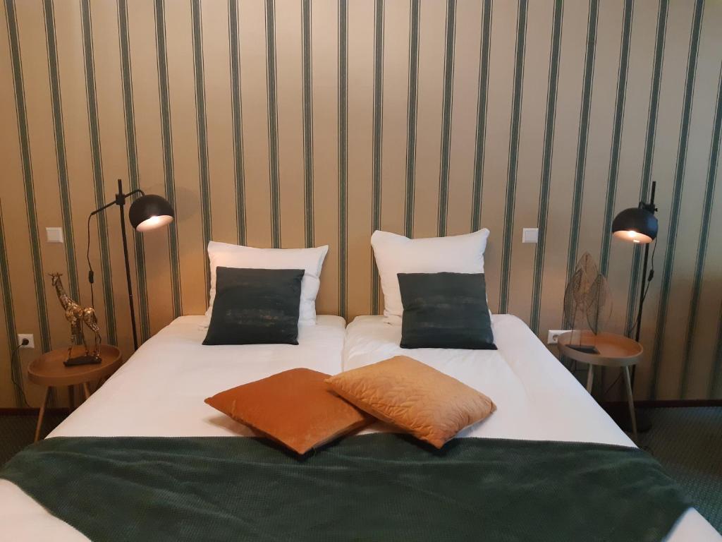 a bed with two pillows on it in a room at Hotel Johannes Vermeer Delft in Delft