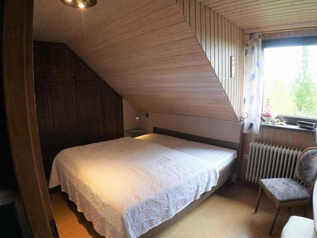 a small bedroom with a bed and a window at Ferienwohnung Am Traumgarten, 35646 in Uplengen