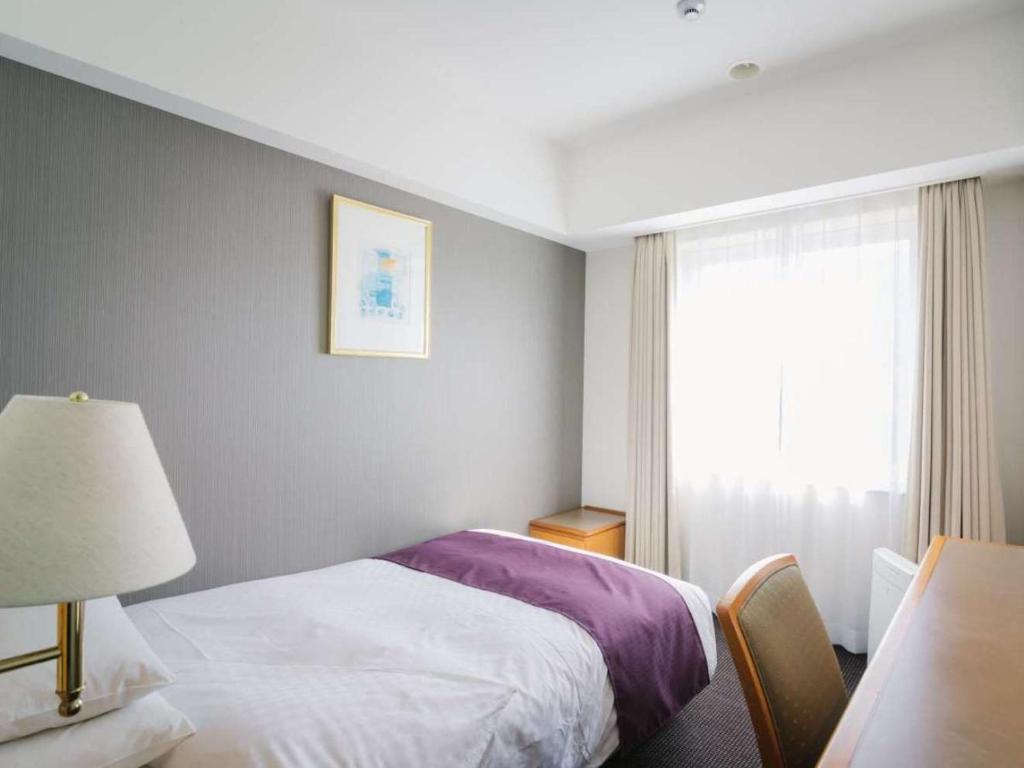 Postel nebo postele na pokoji v ubytování JR Hotel Clement Uwajima