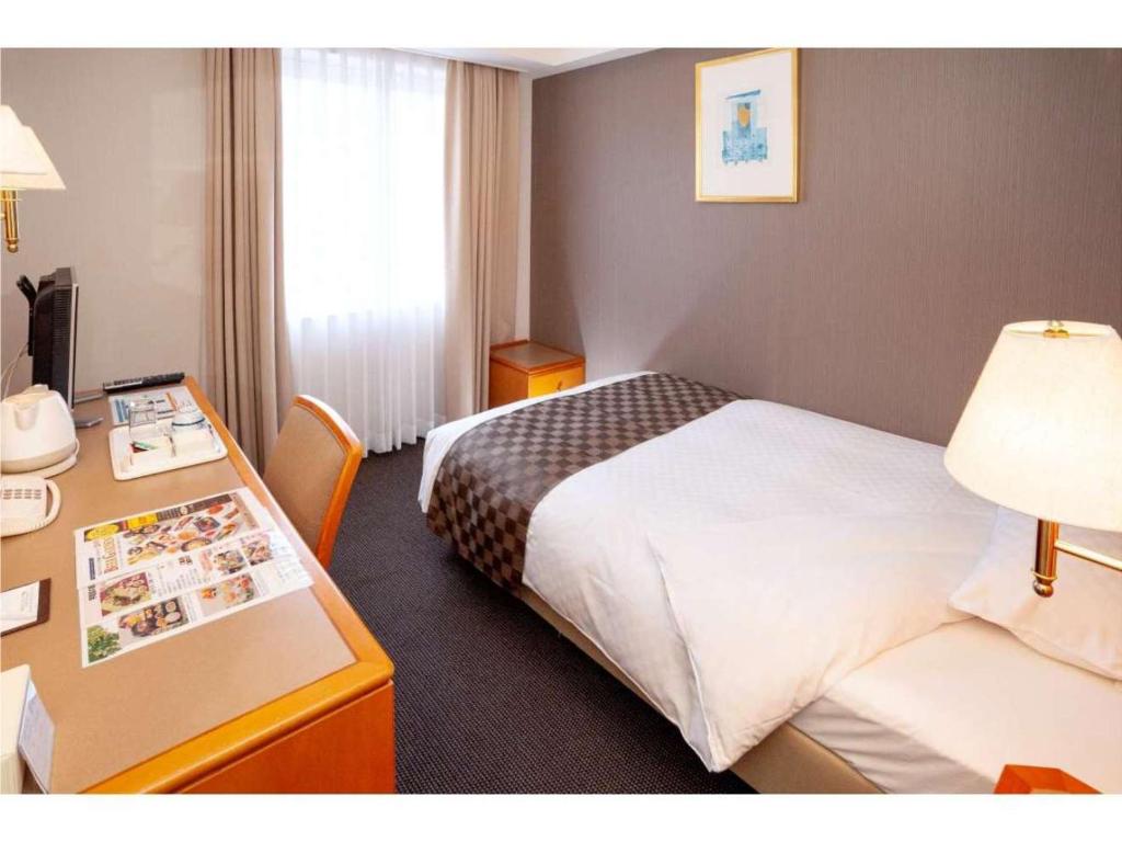 Postel nebo postele na pokoji v ubytování JR Hotel Clement Uwajima