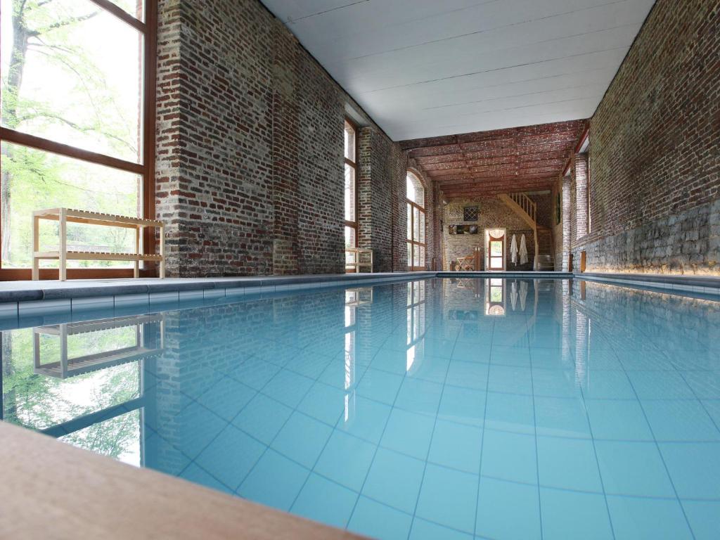una piscina vacía con suelo de baldosa azul y paredes de ladrillo en Cosy holiday home in Wanze with sauna, en Wanze
