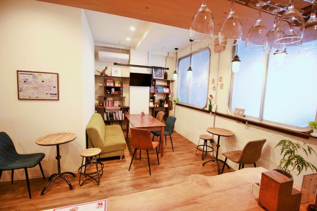 a restaurant with tables and chairs in a room at Hostel TOKI in Fukuoka