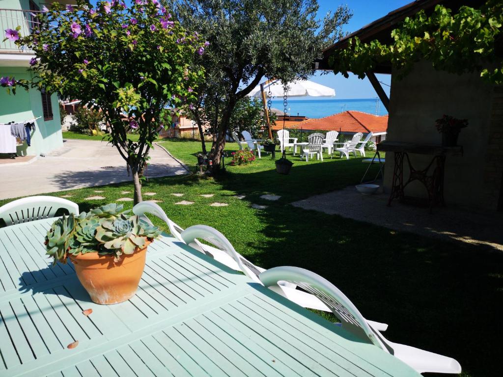 een witte tafel en stoelen met een potplant erop bij Il Tetto Verde in Fossacesia