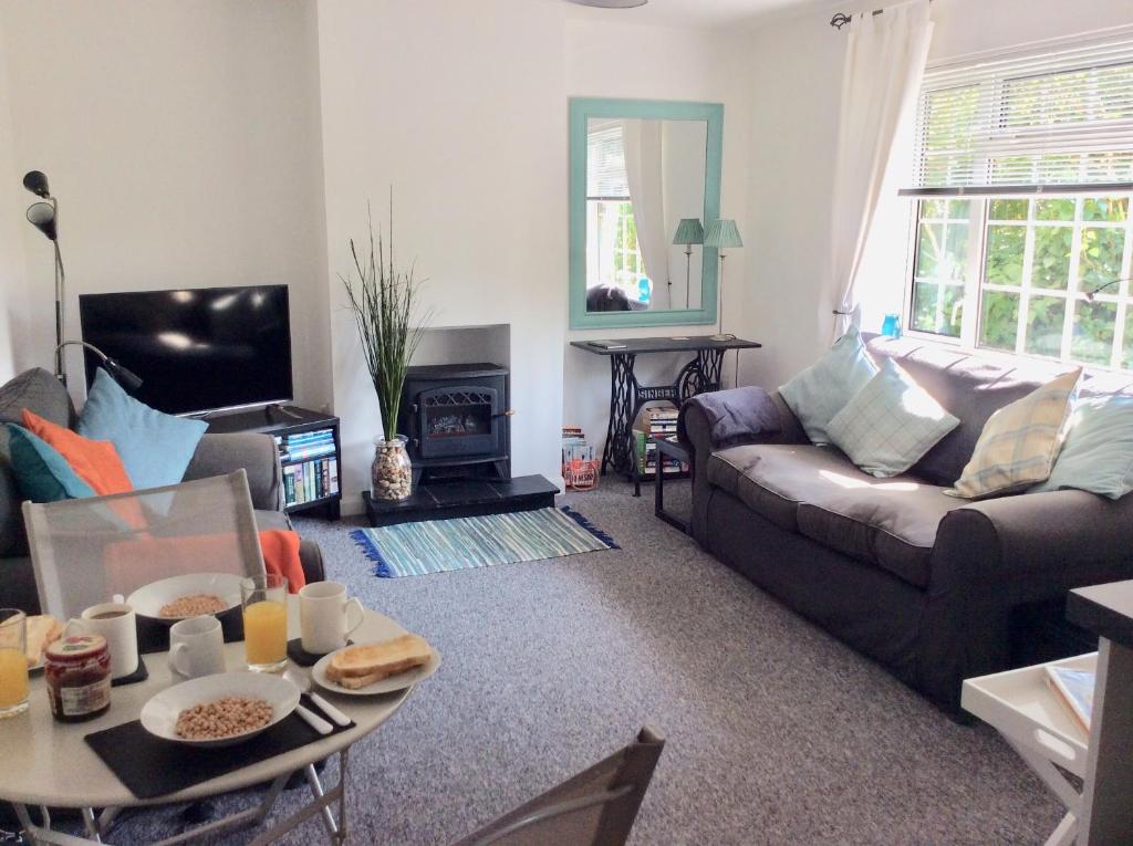 ein Wohnzimmer mit Sofa und Tisch in der Unterkunft River Walk in Lyme Regis