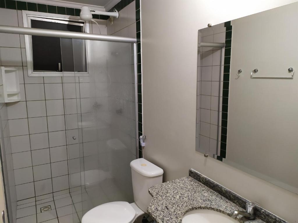 een badkamer met een toilet, een wastafel en een spiegel bij Apartamentos Ecologic PARK - Caldas Novas in Caldas Novas