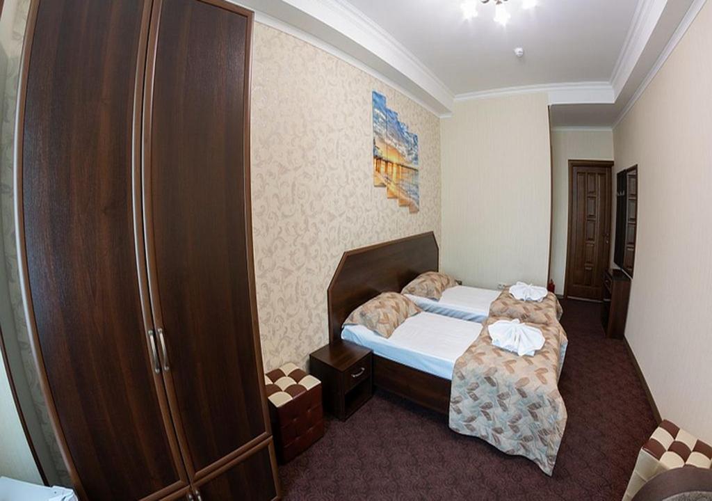 a small bedroom with a bed and a chair at Oscar Mini Hotel in Simferopol