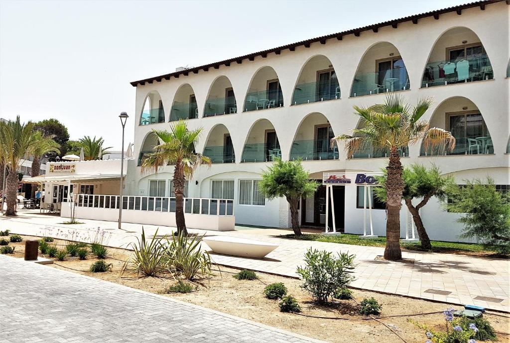 a building with palm trees in front of it at Stil Bonsai in Can Picafort