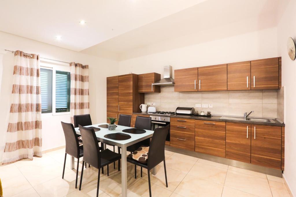 a kitchen and dining room with a table and chairs at Valletta Triton Apartment in Valletta