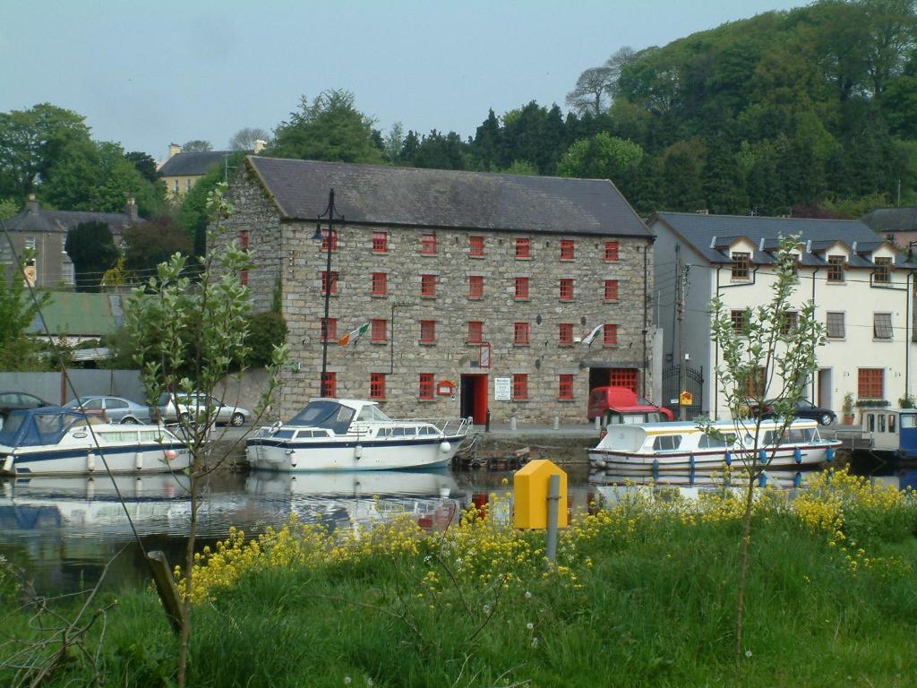 a group of boats docked in front of a building at Waterside Guesthouse in Graiguenamanagh