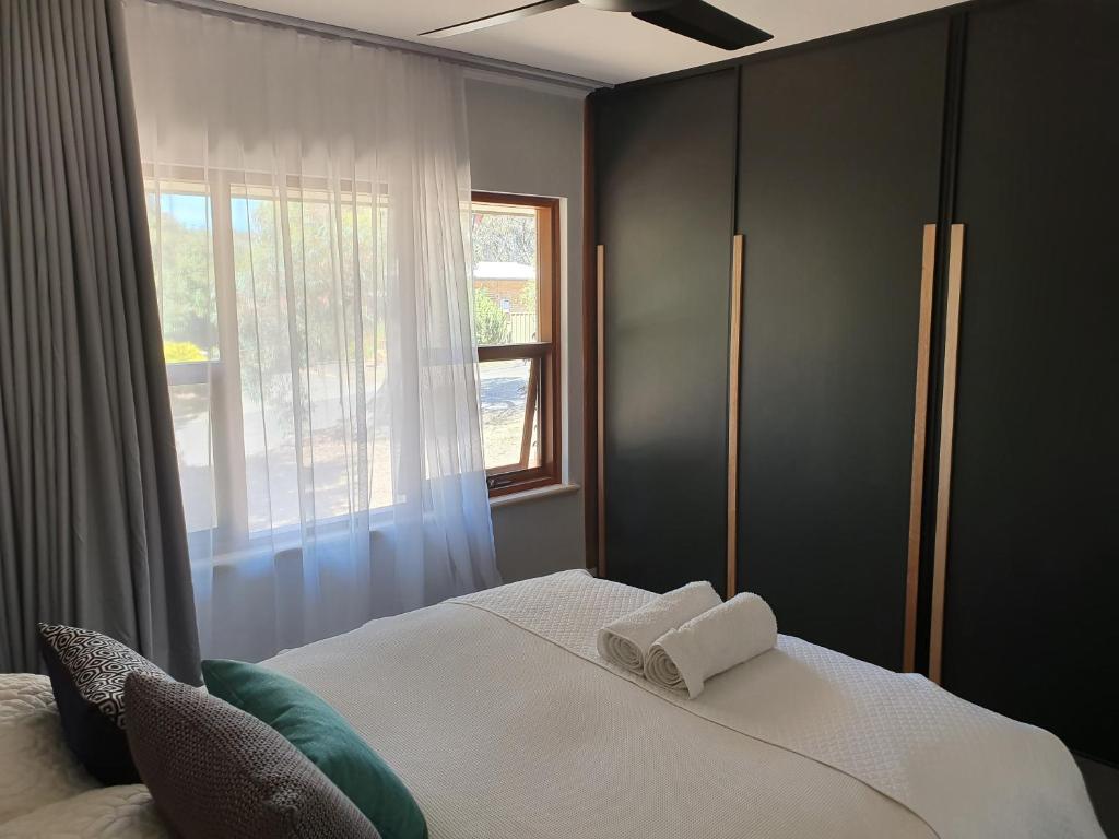 a bedroom with a bed with two towels on it at Seacliff Park Holiday Home in Seacliff