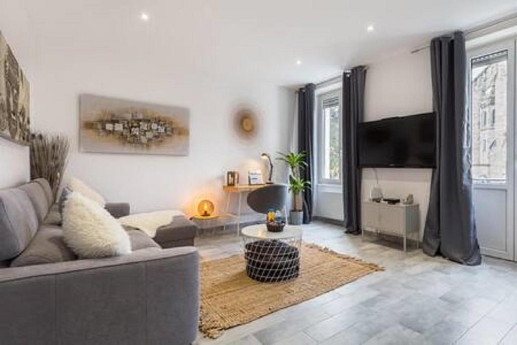 un salon avec un canapé et une télévision à écran plat dans l'établissement SLEEP IN MULHOUSE, à Mulhouse