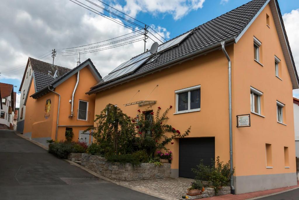 a yellow house with a black roof on a street at Tauber Relax Loft in Tauberbischofsheim