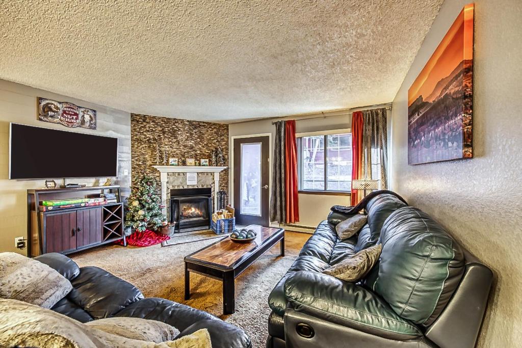 a living room with a leather couch and a fireplace at Giant Steps #40 in Brian Head