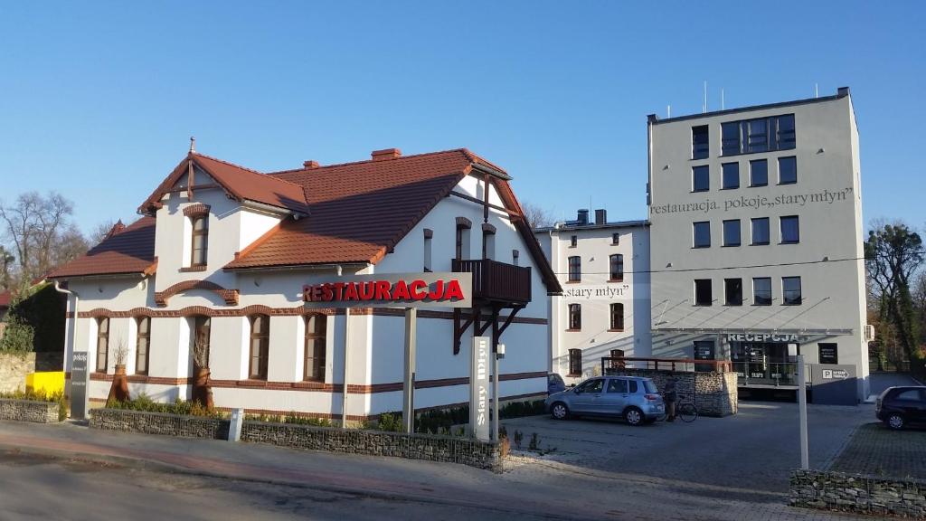 duży biały budynek z znakiem przed nim w obiekcie Stary Młyn w mieście Strzelce Opolskie